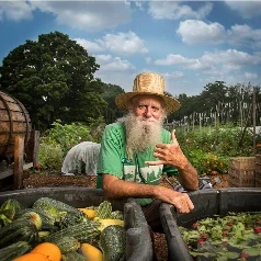 Craig Floyd standing among squash and garden crops