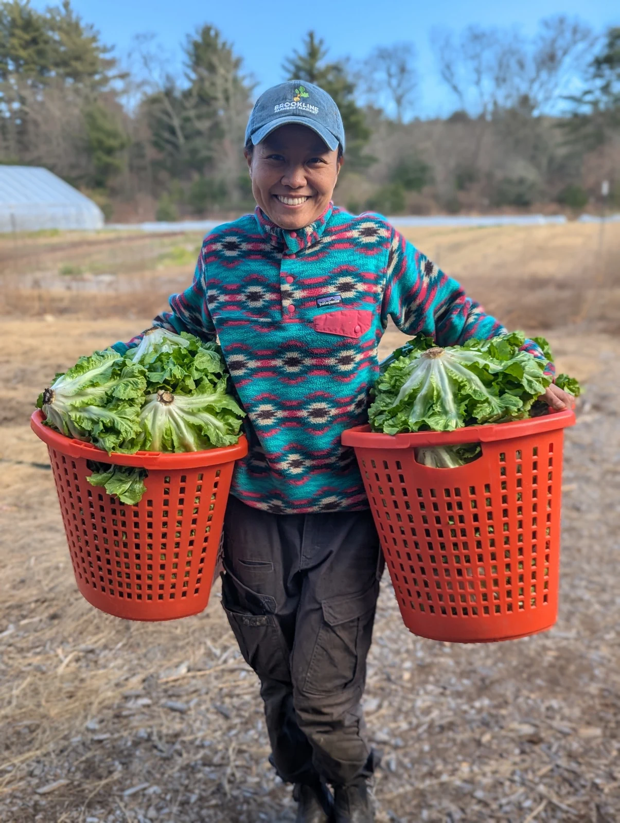 Yoko Takemura carrying two baskets of lettuce
