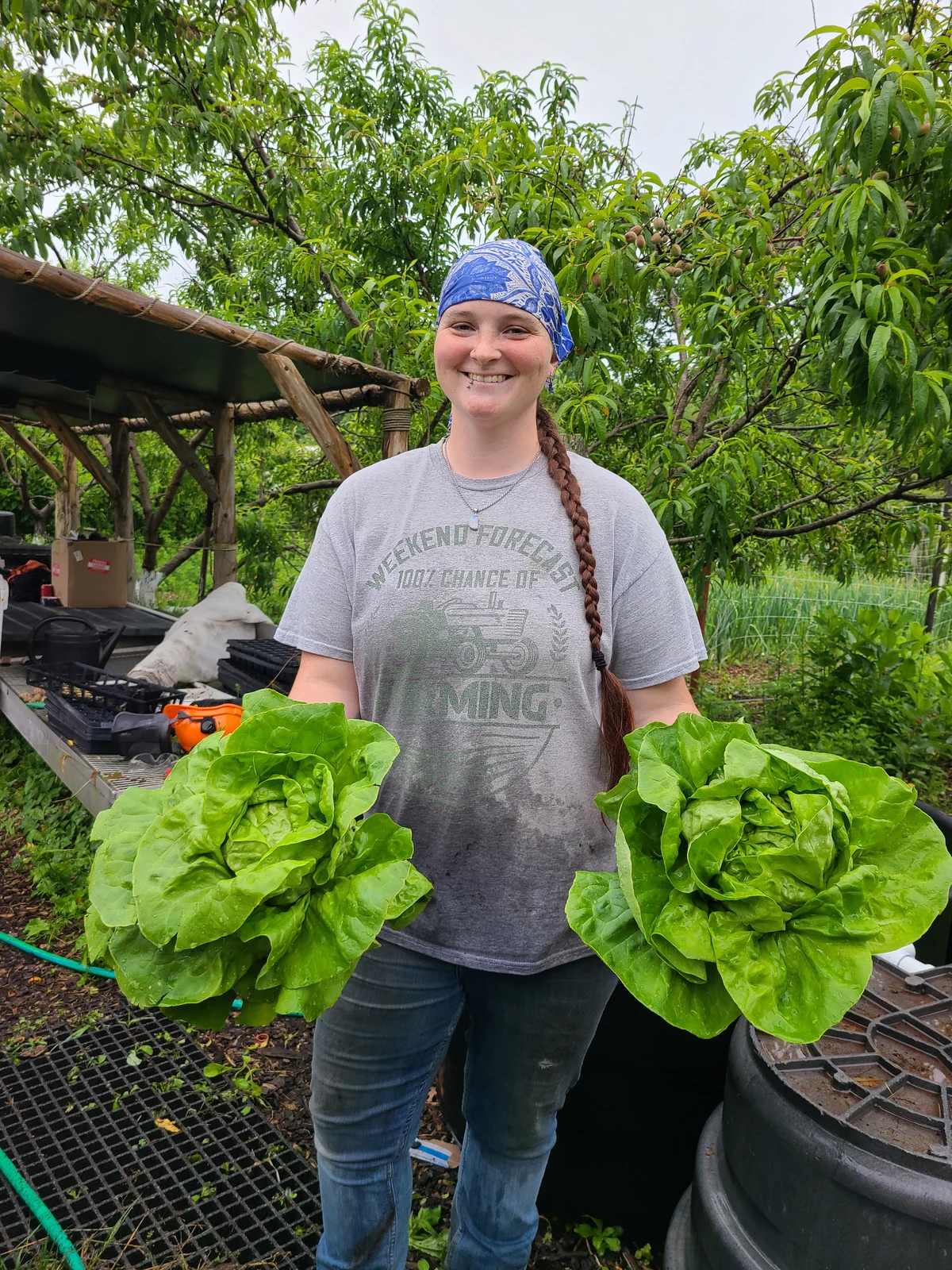 Koralee Lawrence holding two large heads of lettuce